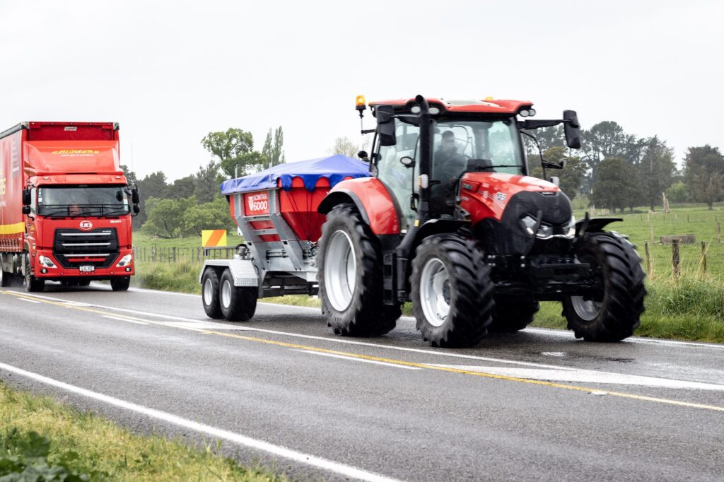 Tractor towing the Scimitar 6000 spreader on a rural road