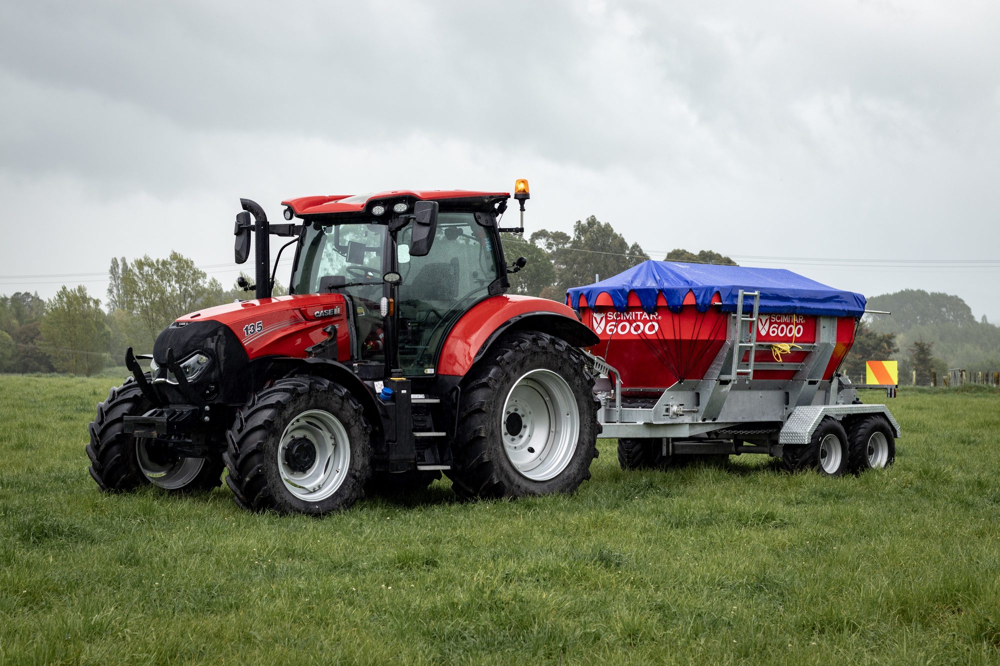 Tractor towing the Scimitar 6000 fertiliser spreader in a paddock